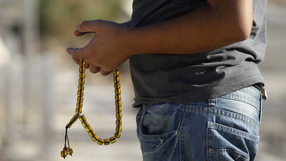 Ein muslimischer Mann hält eine „Misbaha“ genannte Gebetskette in den Händen.Ein muslimischer Mann hält eine „Misbaha“ genannte Gebetskette in den Händen.