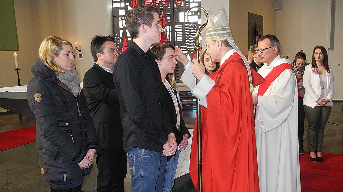 Weihbischof Stefan Zekorn firmt Jugendliche im Berufskolleg St. Michael.