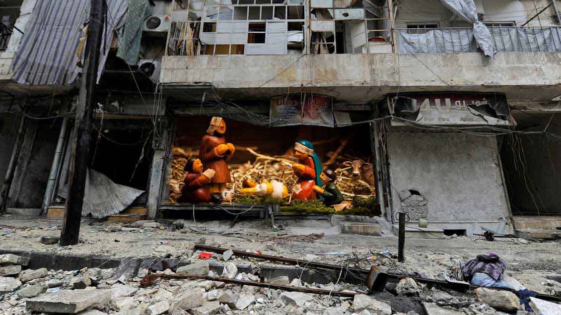 Eine Krippe, montiert in ein Foto aus der kriegszerstörten Stadt Aleppo.