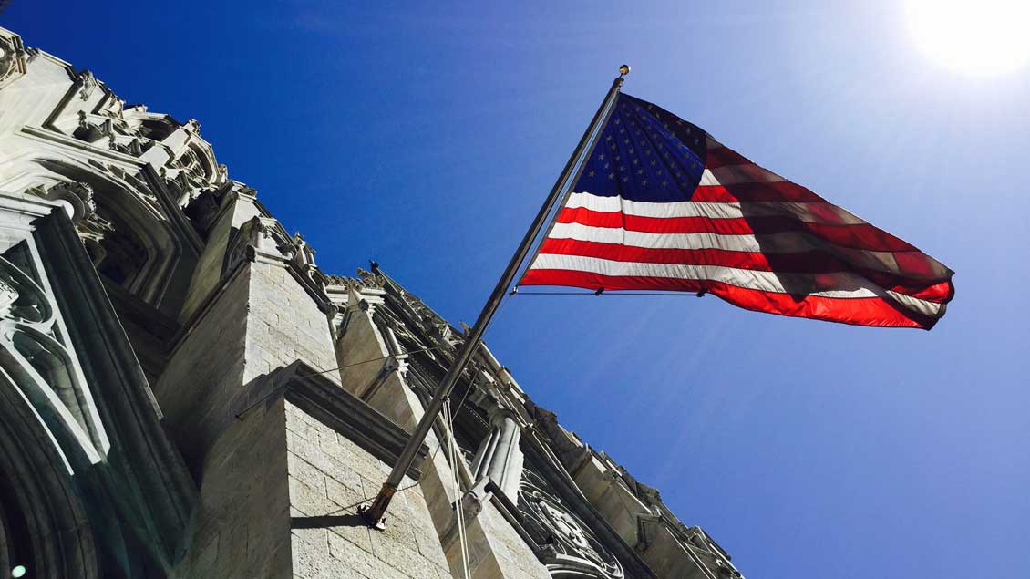 Die amerikanische Nationalflagge an der Fassade der katholischen Kathedrale St. Patrick in New York City.