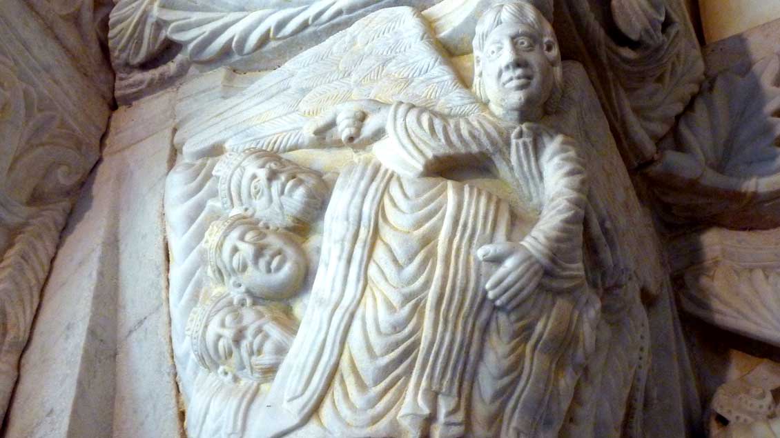 Unter einer Decke steckend wird den Heiligen Drei Königen im Traum von einem Engel ein anderer Rückweg in die Heimat gezeigt: Kapitell im Kreuzgang der Kathedrale von Tarragona (Spanien).