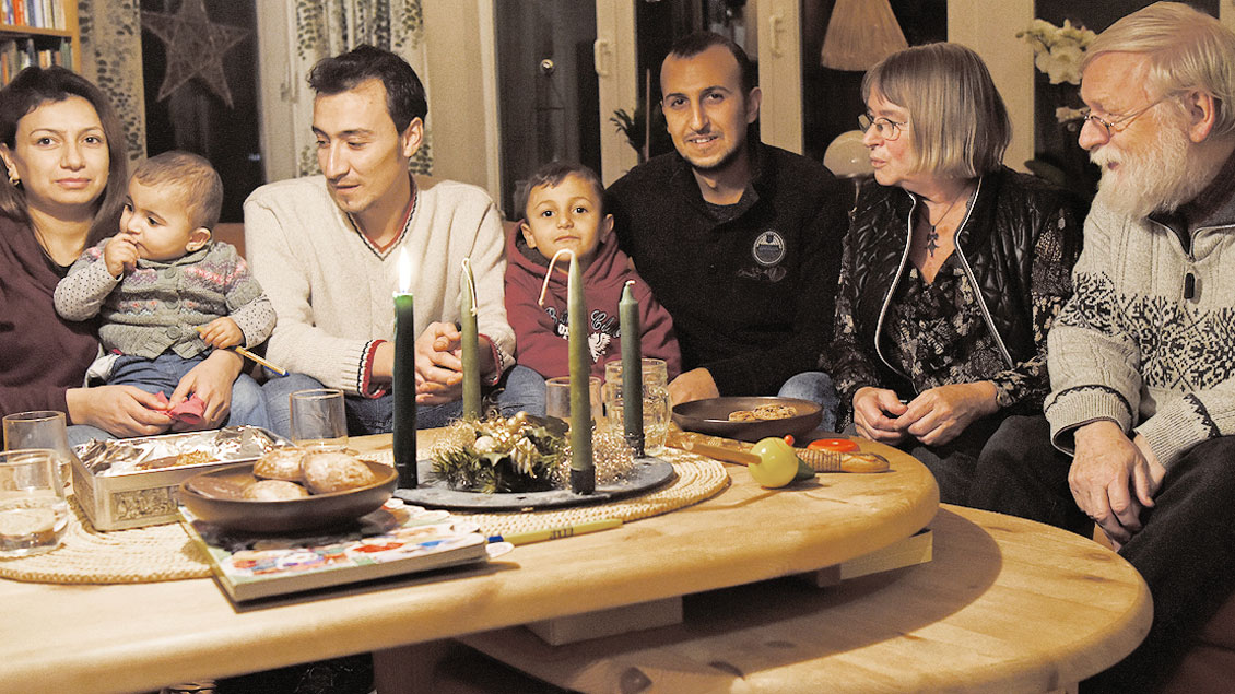 Rudolf und Hedwig Fischer (rechts) am Wohnzimmertisch mit der Familie Hassan.