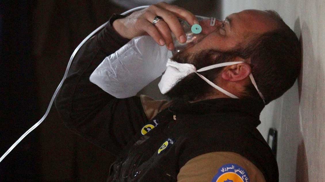 Ein Mitarbeiter des Zivilschutzes atmet in eine Sauerstoffmaske in der Gegend des mutmaßlichen Giftgas-Angriffs in Syrien.