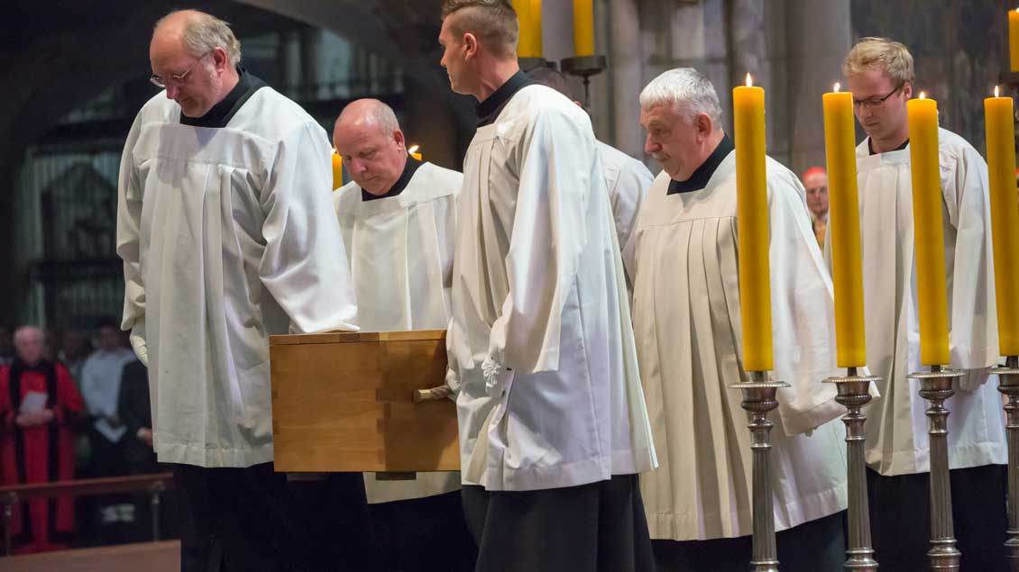 Messdiener tragen den schlichten Eichensarg bei der Begräbnisfeier im Kölner Dom.