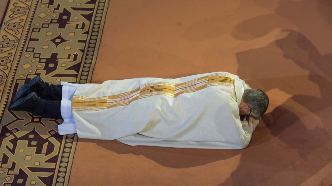 Peter Kohlgraf liegt während der Allerheiligenlitanei vor dem Altar flach auf den Boden.