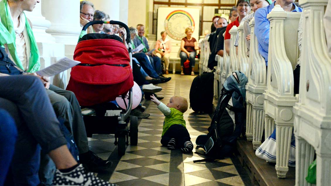 Ein Kind krabbelt durch eine Kirche.