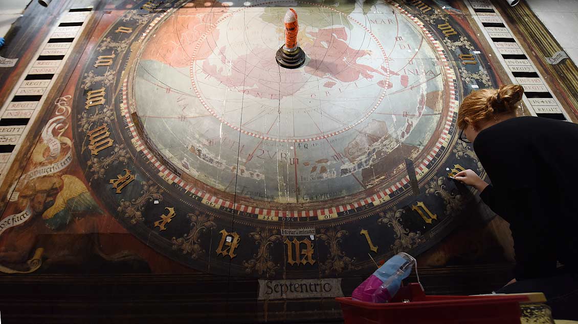 Millimeterarbeit am drei Meter hohen Ziffernblatt: Restauratorin Charlotte Hoffmann beschäftigt sich mit dem Zahlenkranz der Astronomischen Uhr. | Foto: Michael Bönte