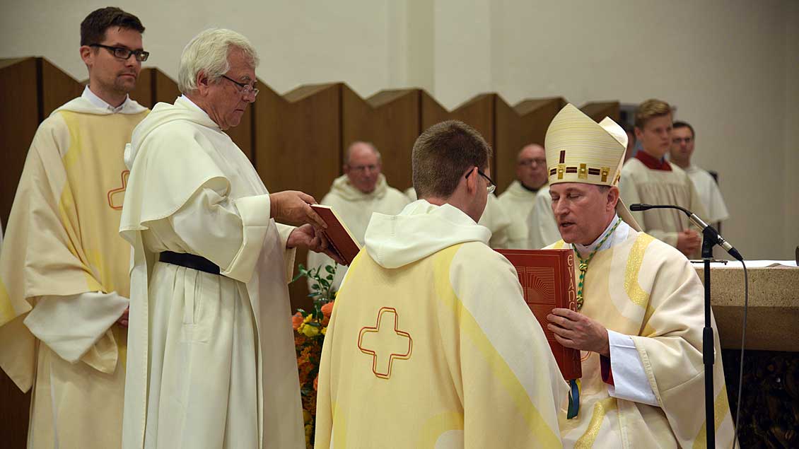 Weihbischof Wilfried Theising überreicht Fr. Christoph Tobias Brandt OP das Evangeliar.