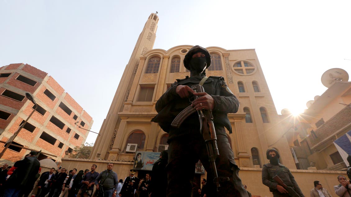 Sicherheitsbeamte stehen vor der Mar-Mina-Kirche in Helwan im Süden Kairos, auf die am Freitag ein Anschlag verübt wurde. Dabei sind mindestens neun Menschen getötet worden.