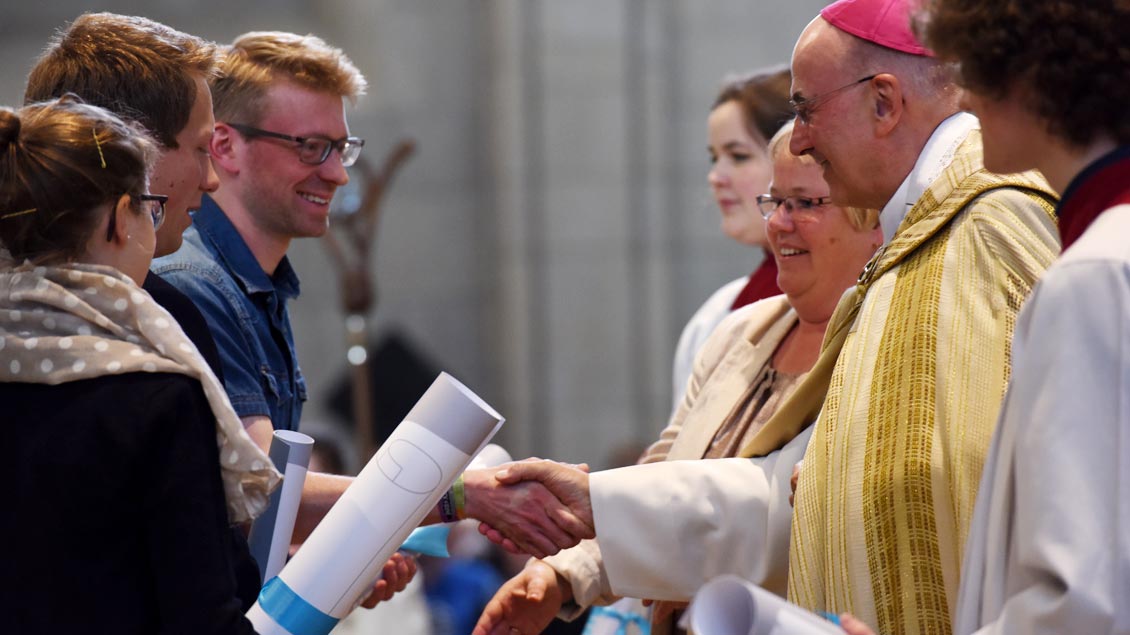 Bischof Genn überreicht während der „Aufklang“-Veranstaltung zum Katholikentag im Mai 2017 leere Friedensverträge an Menschen aus dem Bistum.