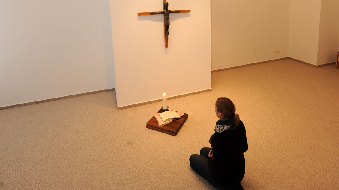 Gebet vor einem Kreuz