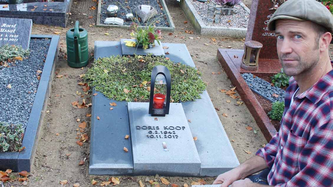 Rainer Kuehn zeigt das Grab, das er umgestalten muss. Die Gestaltung verstößt gegen die Friedhofssatzung der Pfarrei, die am 1. Januar 2016 in Kraft getreten ist.