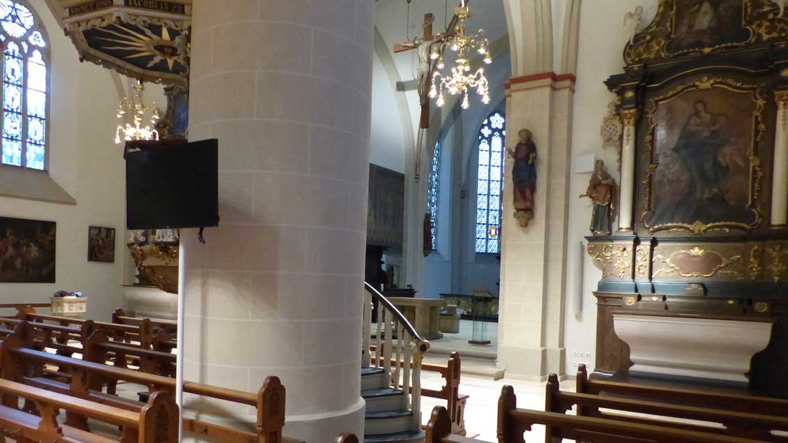 Vor einer Säule in St. Georg in Vechta steht ein Monitor.