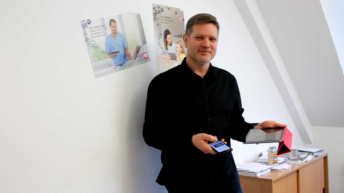 Rüdiger Dreier mit Smartphone und Tablet in der Hand.