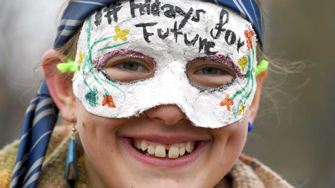 Eine Schülerin mit einer Maske, auf der „Fridays for Future“ steht