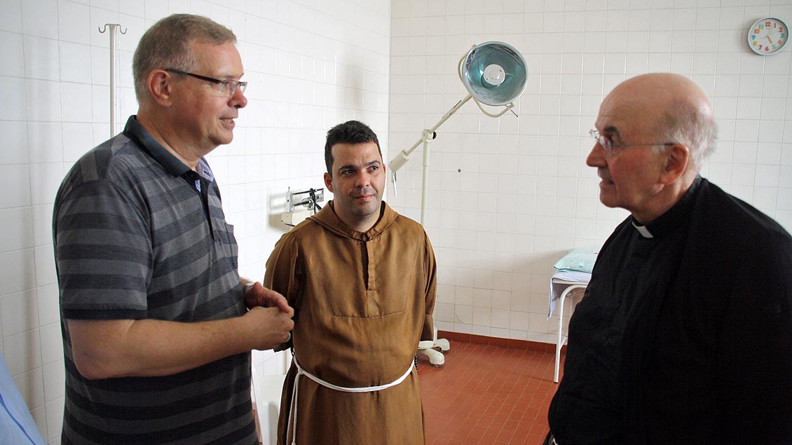 Der aus dem Bistum Münster stammende Bischof Johannes Bahlmann (links) erläutert Bischof Felix Genn die augenblickliche Versorgung der Kranken in Óbidos.
