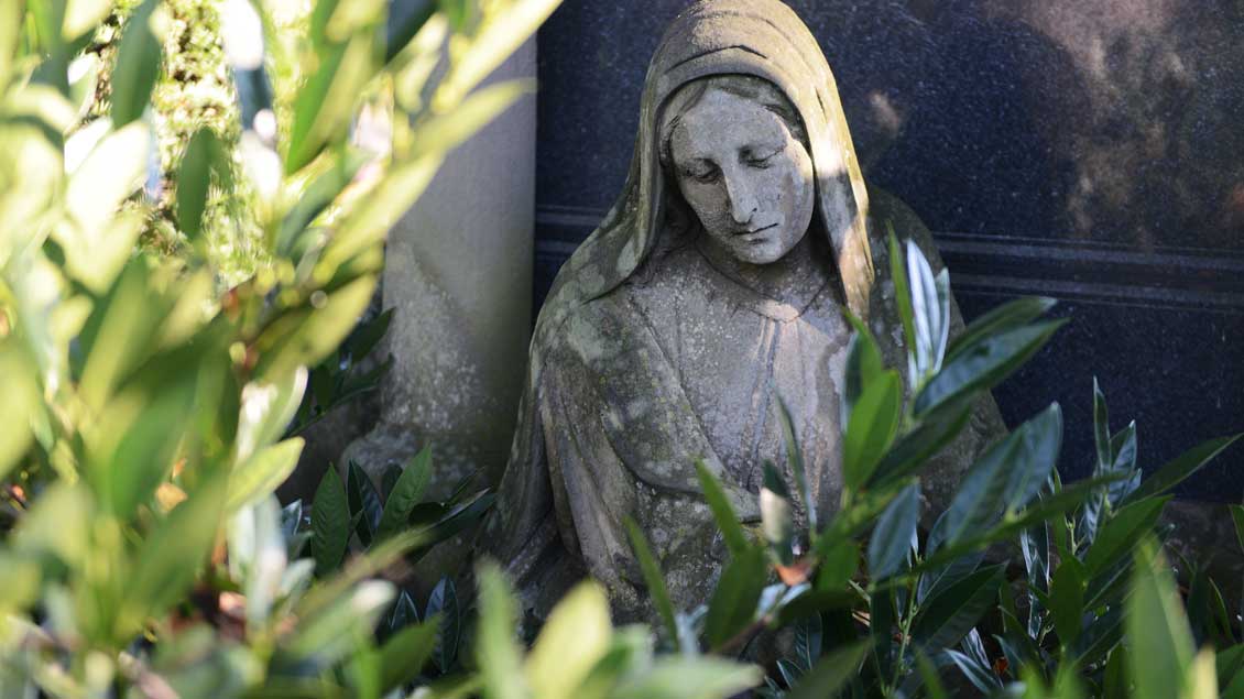 Marienfigur auf einem Friedhof.