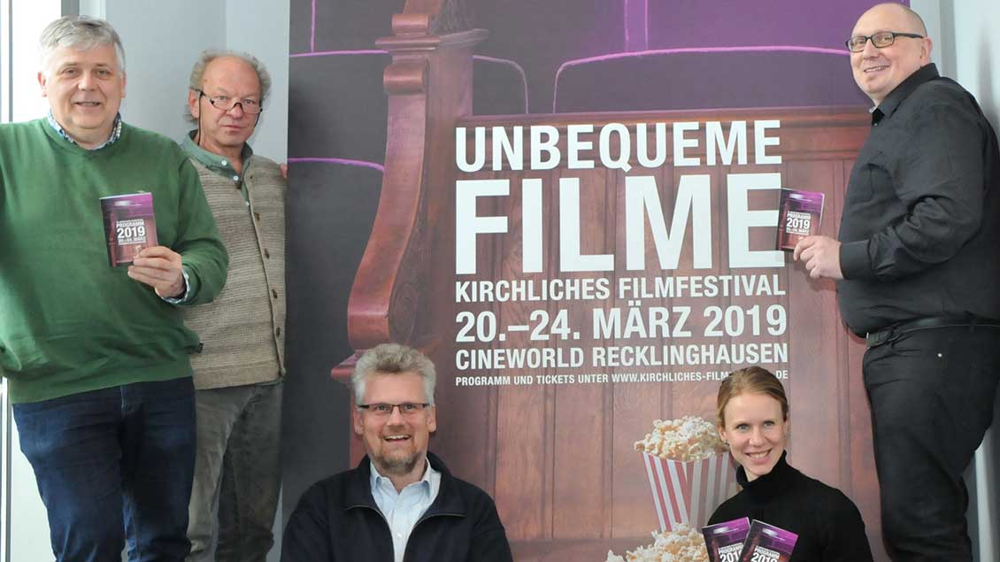 Die Veranstalter des kirchlichen Filmfestivals Recklinghausen mit dem Programmheft in der Hand.