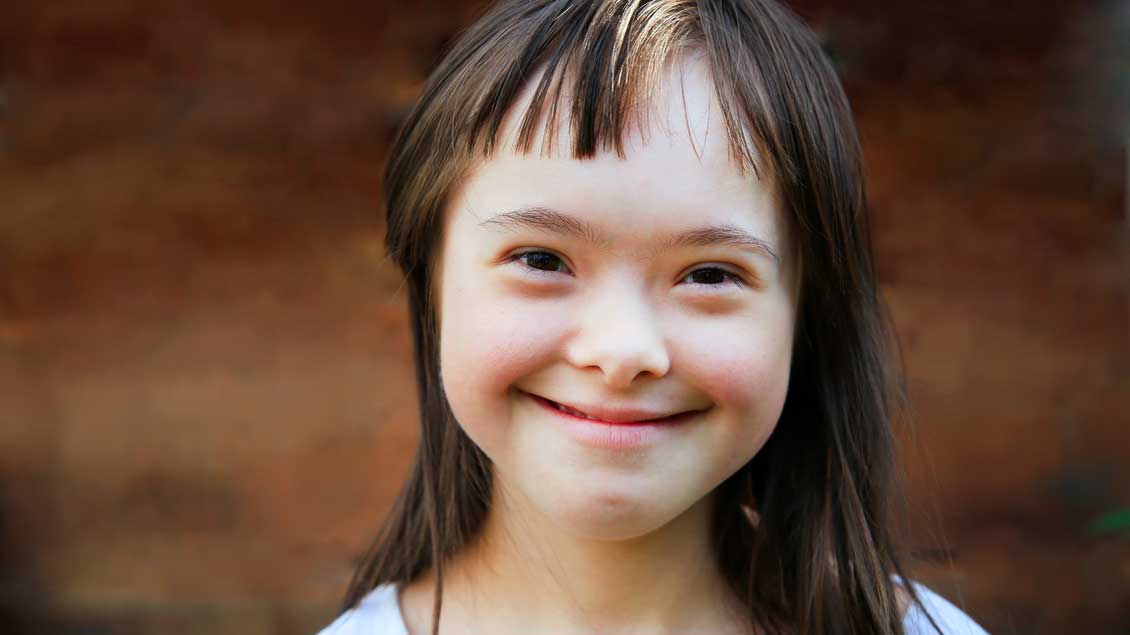 Ein lächelndes Kind mit Down-Syndrom