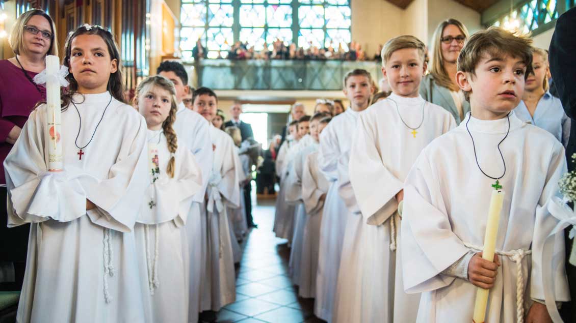 Erstkommunionkinder ziehen zu Beginn des Gottesdienstes in die Kirche ein