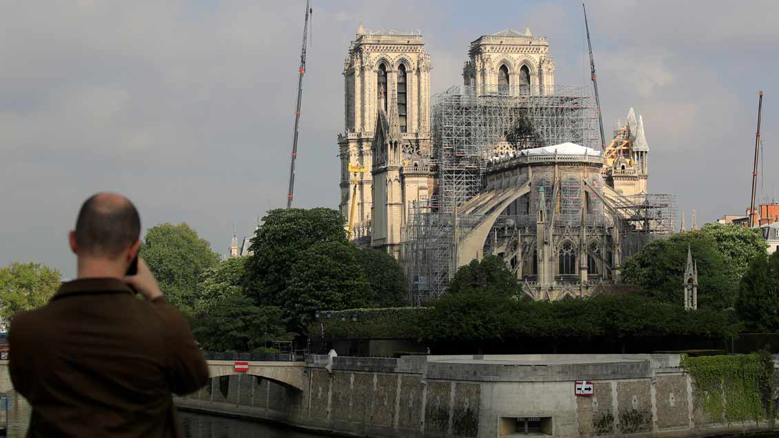 Ein Mann fotografiert Reparaturarbeiten am 29. April an Notre-Dame in Paris.