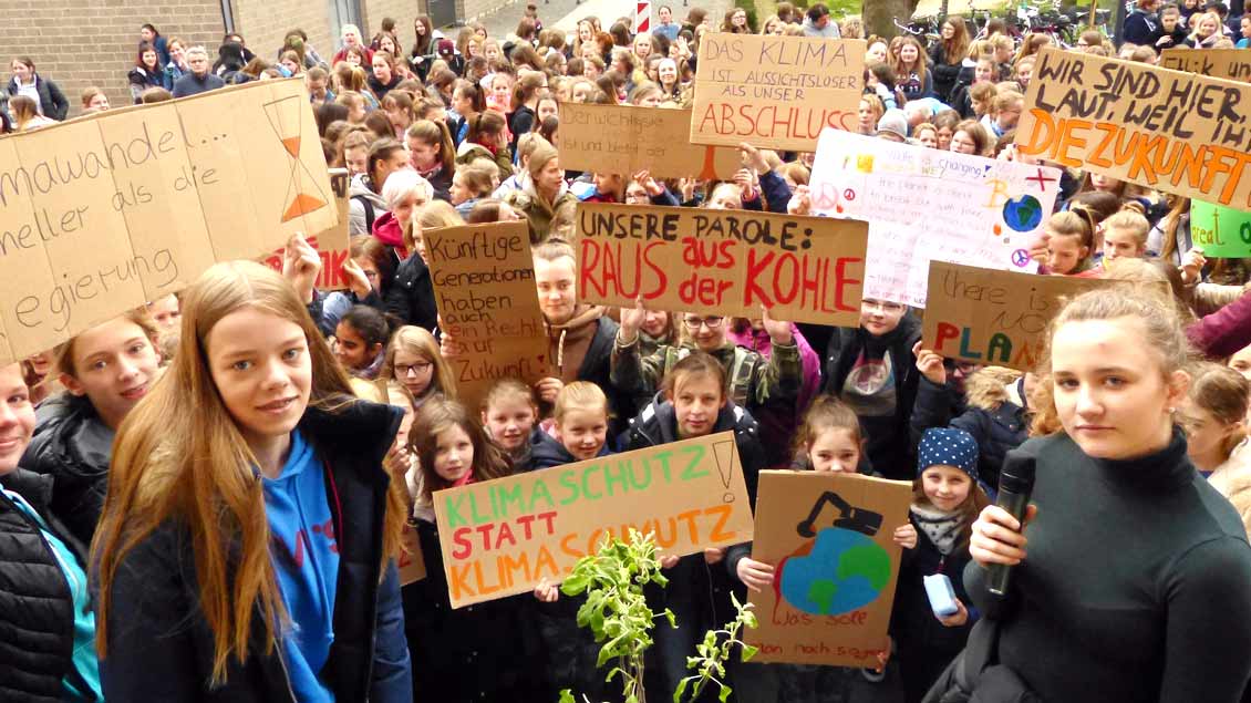 SChülerinnen der Marienschule in Xanten halten Plakate zum Klimaschutz hoch.