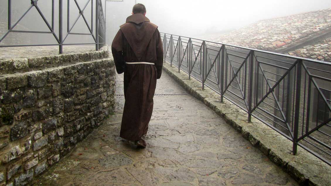 Ein Mönch geht allein im Nebel