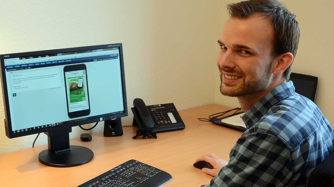 Pastoralreferent Christian Winnemöller sitzt vor dem Computer auf dem das Programm für die Ostergeschichte per "WhatsApp" läuft.