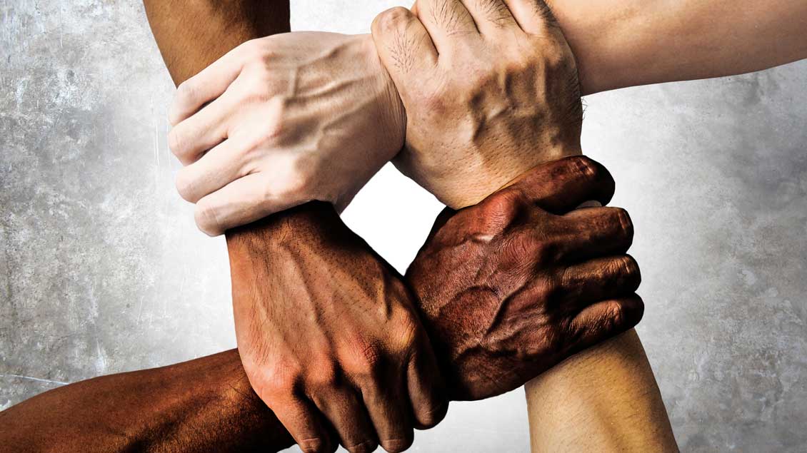 Vier Hände unterschiedlicher Hautfarbe