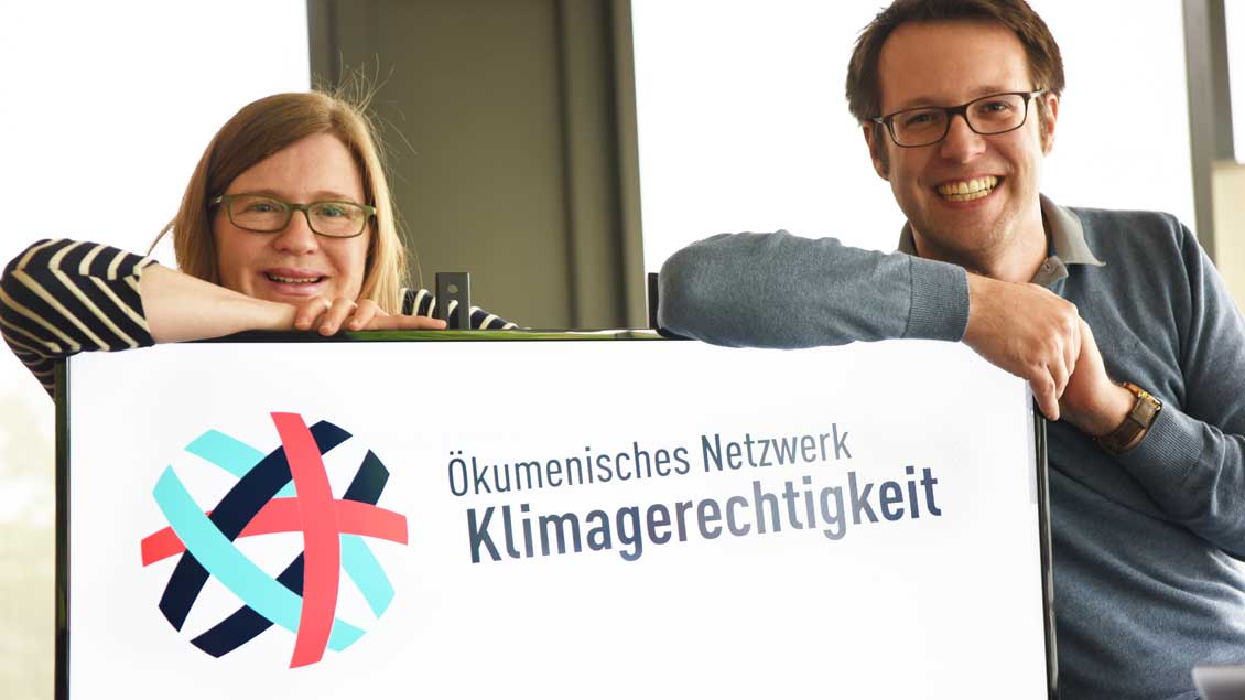 Monika Schell und Chris Böer mit einem Banner des Ökumenischen Netzwerks Klimagerechtigkeit. 