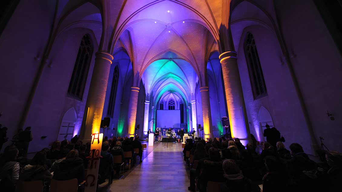 Die Jugendkirche Effata in Münster ist während eines Gottesdienstes farbig ausgeleuchtet.