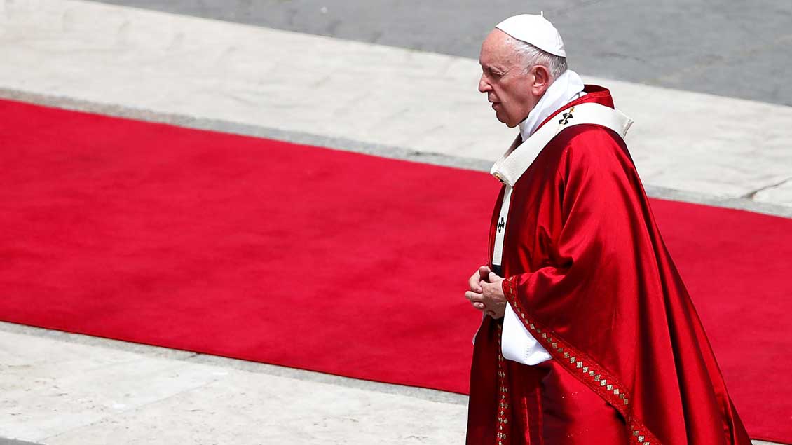 Papst Franziskus in rotem Gewand auf dem Petersplatz