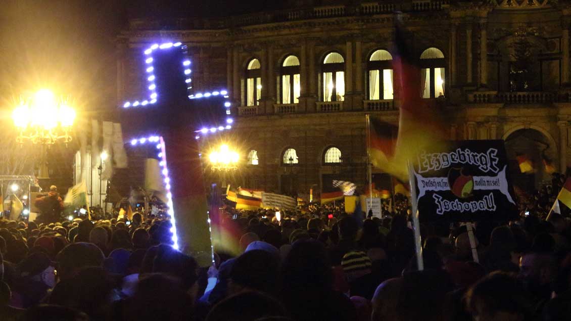 Pegida-Demonstration mit Kreuz und Deutschlandfahne in Dresden