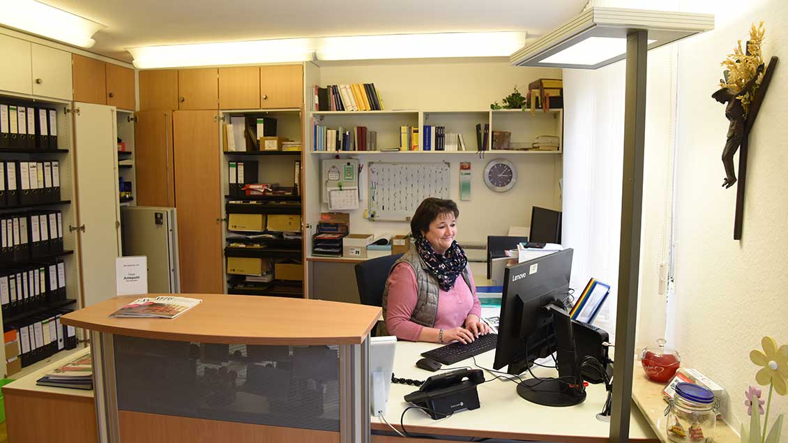 Eine Pfarrsekretärin arbeitet in ihrem Büro.