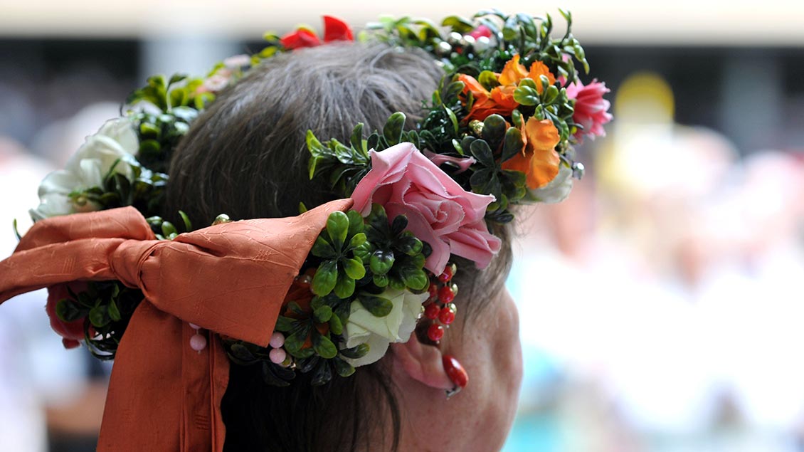 Eine Frau trägt einen Blumenkranz in den Haaren.
