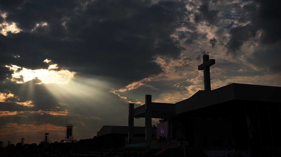 Dunkle Wolken über einem Kreuz