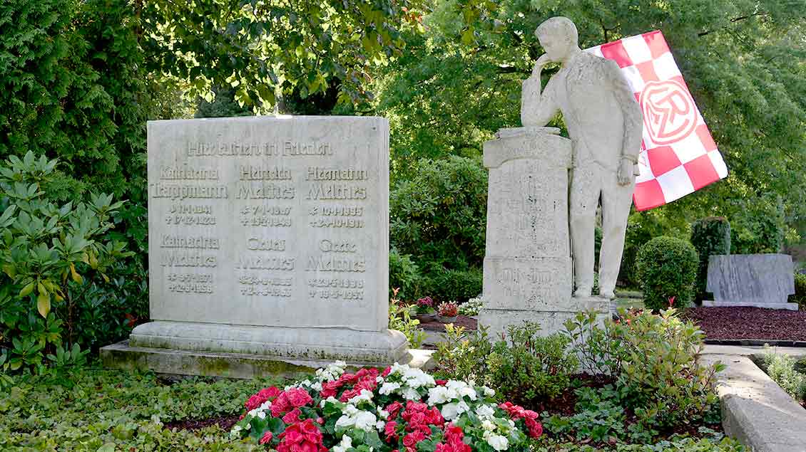 Das Grab des Vereinsgruenders des Fußballklubs Rot-Weiss Essen (RWE), Georg Melches, und seiner Familie. Dekoriert mit einer RWE-Fahne.