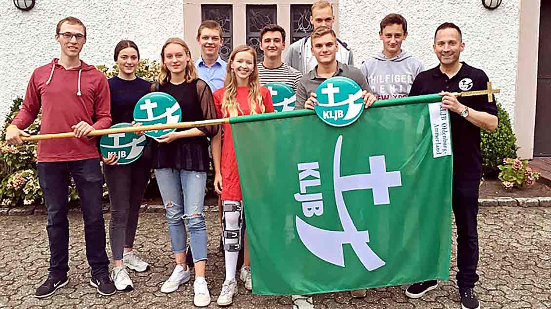 Pfarrer Jan Kröger und der Vorstand der neuen KLJB-Ortsgruppe Oldenburg-Ammerland mit der grün-weißen KLJB-Fahne.