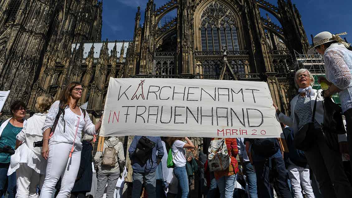 Frauen halten vor dem Kölner Dom ein Banner mit der Aufschrift "Kirchenamt in Frauenhand" bei einer Demonstration der Initiative Maria 2.0 am 22. September 2019 in Köln.