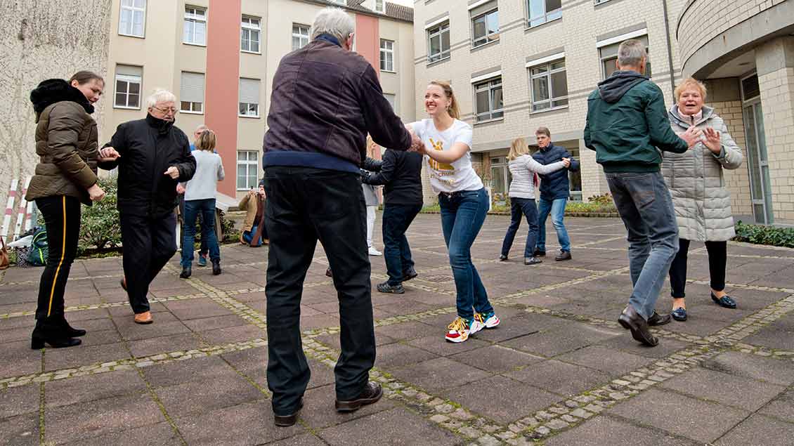 Frauen und Männer tanzen vor der Raphaelsklinik Münster