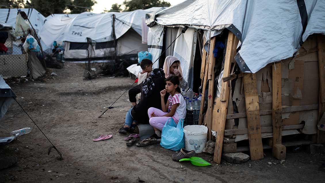 Provisorisches Flüchtlingslager auf Lesbos. Frauen und Kinder sitzen vor den Hütten.