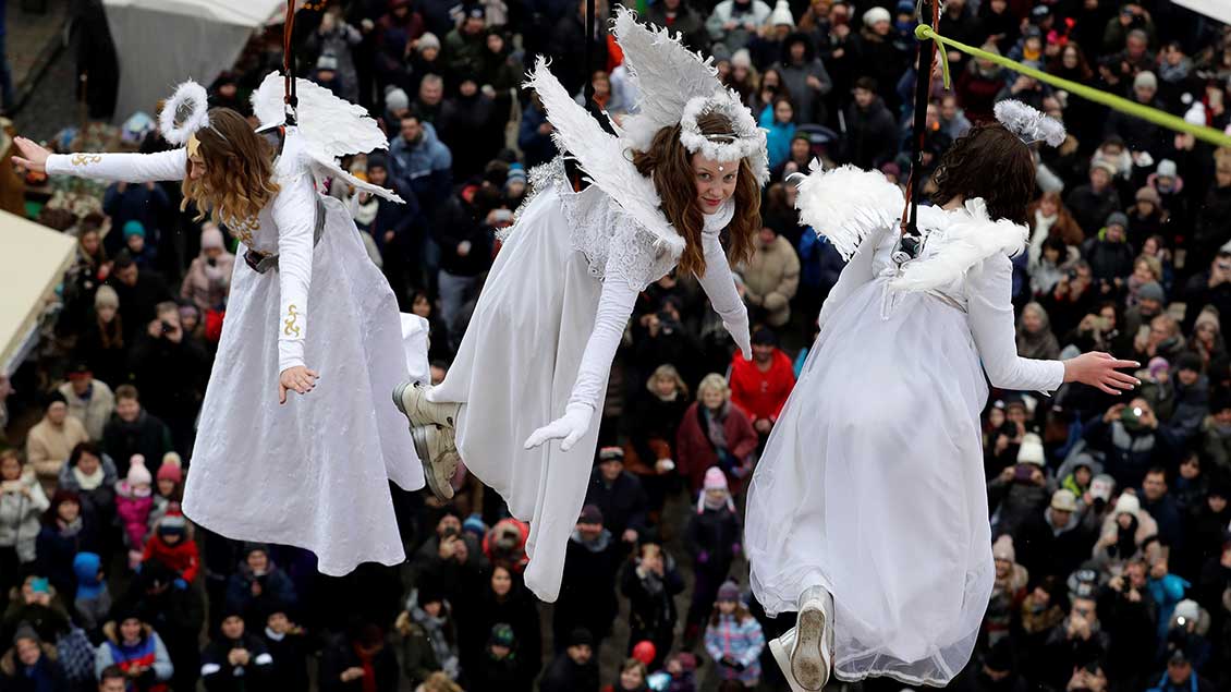 Als Engel verkleidete junge Frauen schweben über den Besuchern des Weihnachtsmarkts der tschechischen Stadt Ustek.