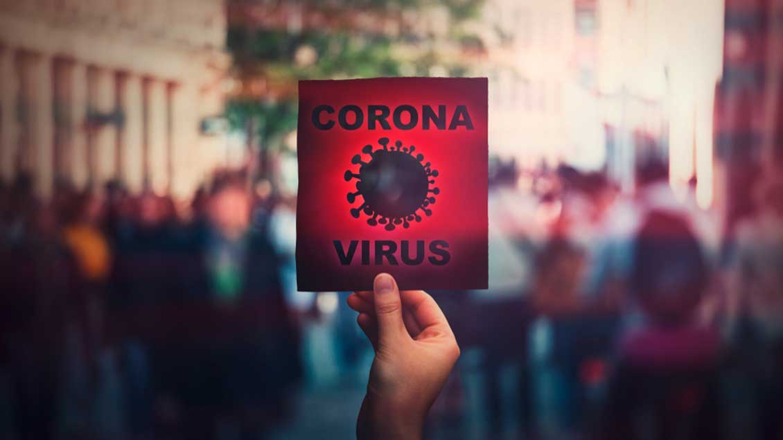 Schild: Corona-Virus vor Menschenmenge
