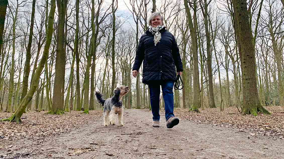 Monika Vernauer mit ihrem Hund Eddi im Wald.