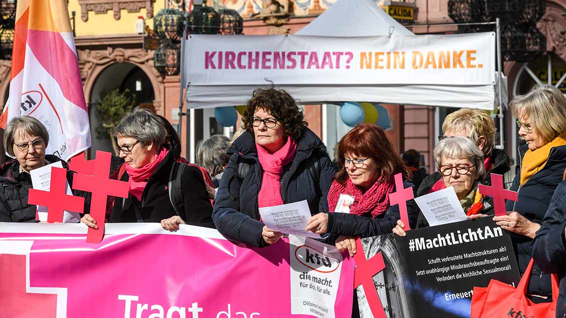 Frauen halten bei der DBK-Vollversammlung in Mainz Protest-Plakate in die Höhe.