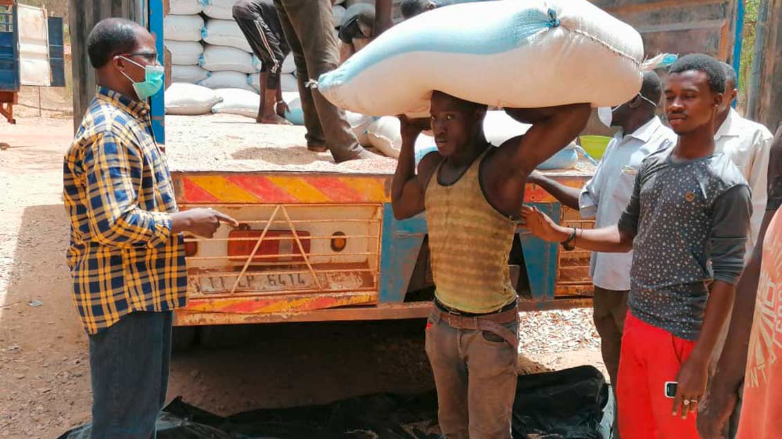 Afrikaner laden Hilfsgüter von einem Kleinlaster.