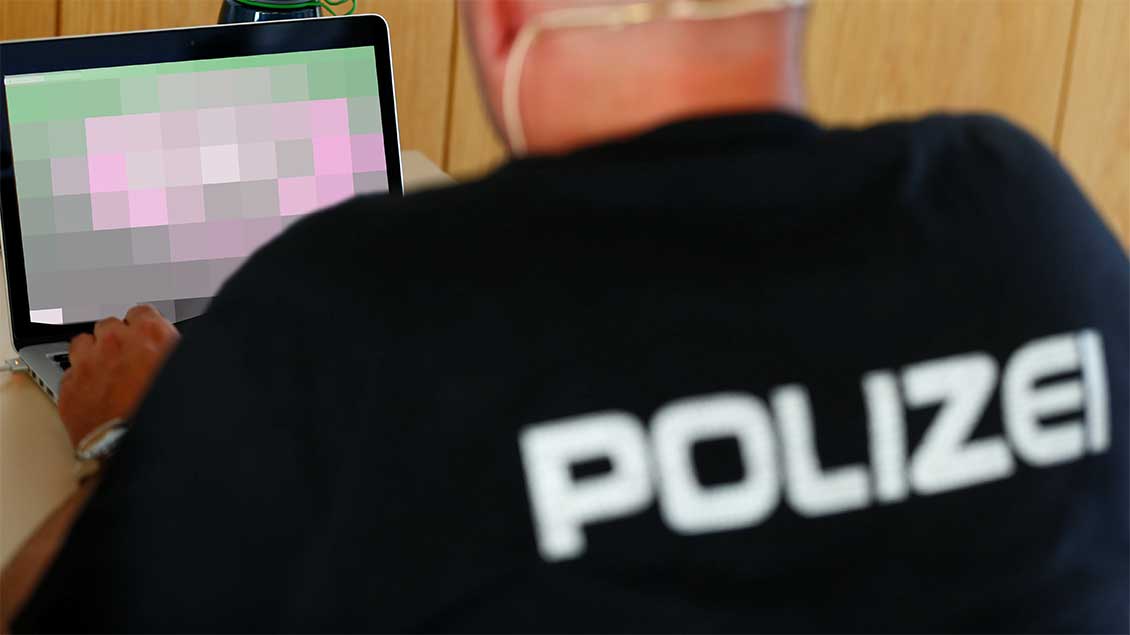 Polizist vor einem Laptop.