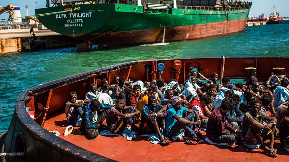 Migranten sitzen an Deck des Schiffes William Butler Yeats der irischen Marine bei dessen Ankunft im Hafen von Augusta (Sizilien) am 3. September 2017.