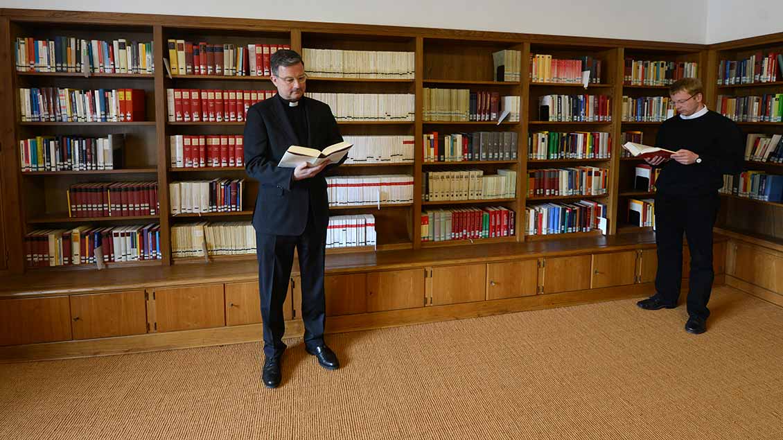 Priester in einer Bibliothek