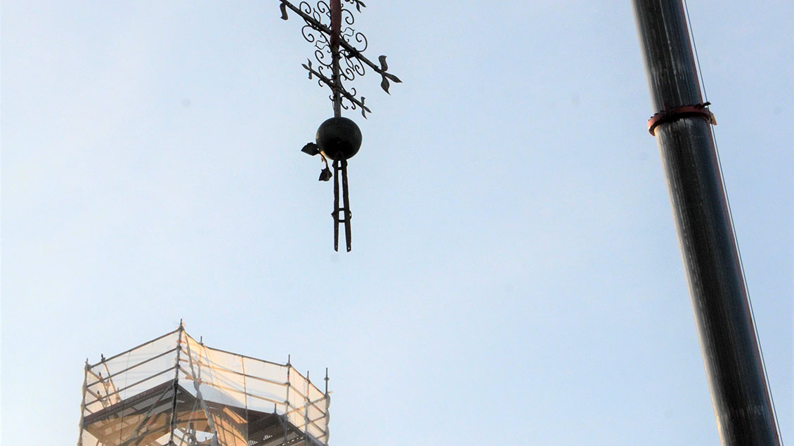 Das Kreuz mit einem Kran vom Turm gehoben